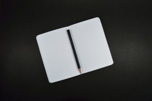 writing in a notebook with a pen